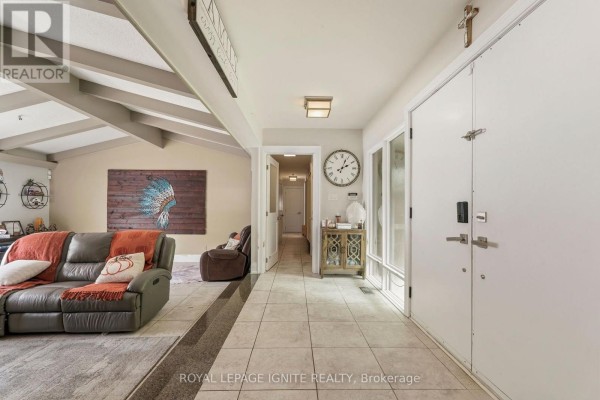 Interior hallway with tiled floors, leading to a living area with a sofa and armchair. - 8 Ridgevale Drive, Markham