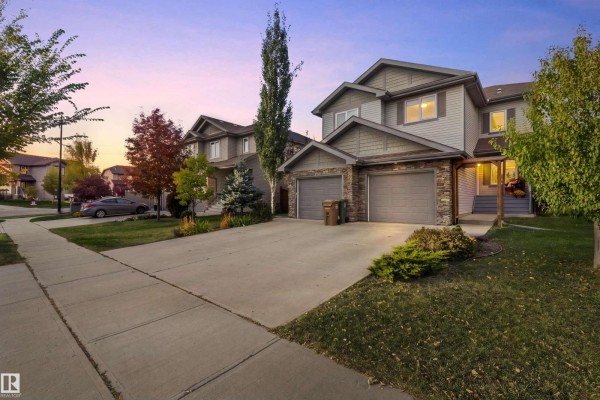 Duplex exteriors at dusk with warm lights visible in the windows. - 8 Royal St, St  Albert