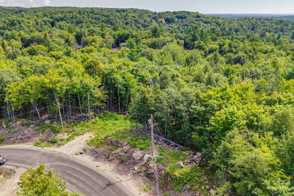 Aerial view of a sloping wooded lot with power lines and a paved road. - 8 Rue Tex-lecor, Cantley