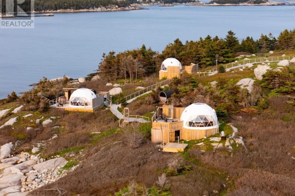 Three geodesic dome structures with wooden decks and stairs on a grassy, rocky island. - 8 Simmons Island, Water Access, West Dover