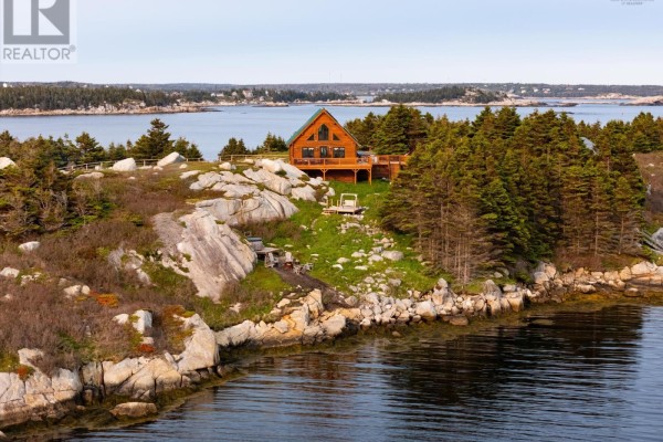 A wooden cabin with a deck sits on a grassy, rocky island overlooking the water. - 8 Simmons Island, Water Access, West Dover