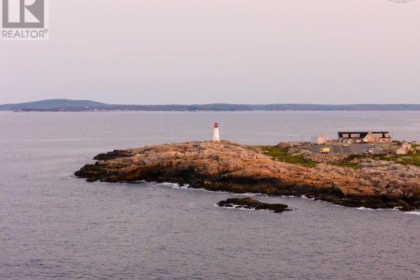 A lighthouse and building are on a rocky point with water surrounding the island. - 8 Simmons Island, Water Access, West Dover