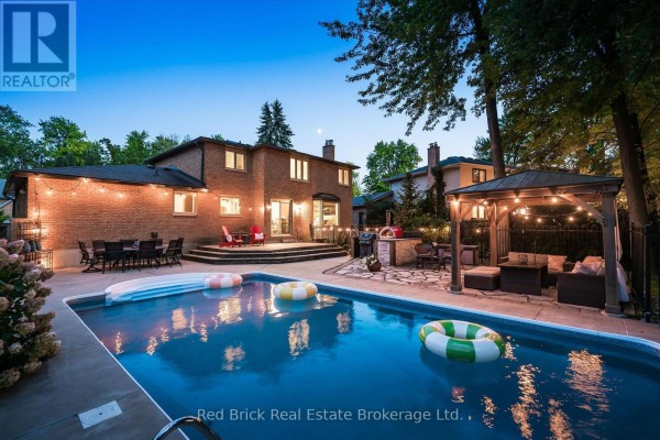 Backyard with a swimming pool, patio with outdoor furniture, and covered gazebo. - 8 Sugarbush Place, Guelph
