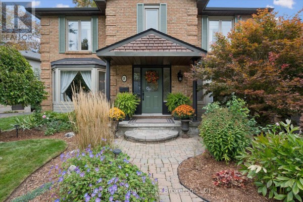 Front entrance with a winding stone path through lush gardens and mature trees. - 8 Sugarbush Place, Guelph