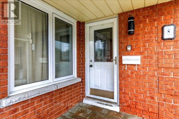 Close-up view of a white front door and mailbox on a red brick house. - 8 Vail Meadows Crescent, Clarington