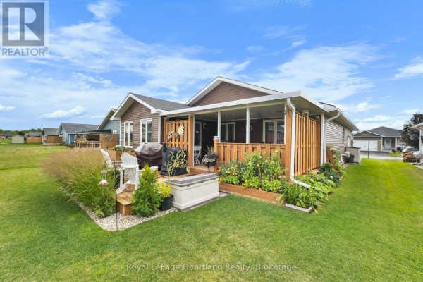 Side view of the house featuring a wooden deck and garden area. - 8 Windward Way N, Ashfield Colborne Wawanosh