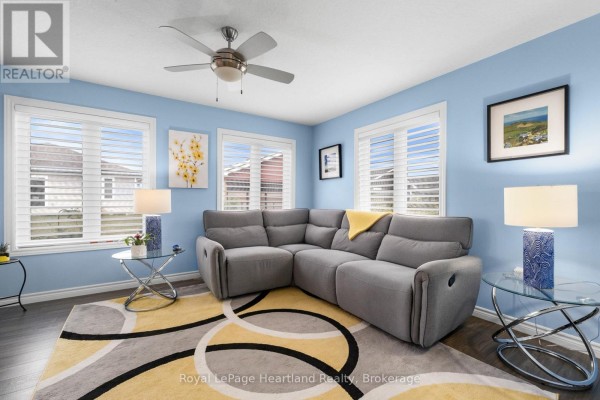 Living room with a sectional sofa, ceiling fan, and large windows. - 8 Windward Way N, Ashfield Colborne Wawanosh