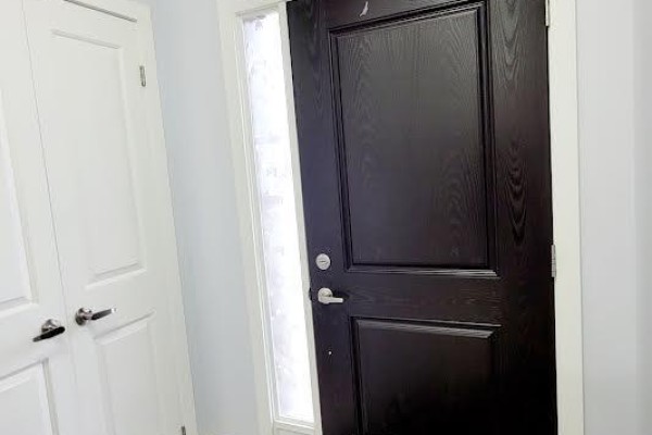 Close-up of a black front door with a glass sidelight and white interior door. - 80 - 1375 Whetherfield Street, London North