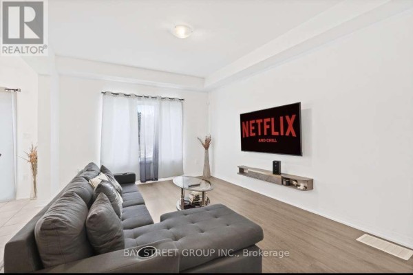 Living room with a large sectional sofa, coffee table, and wall-mounted television. - 80 - 4552 Portage Road, Niagara Falls