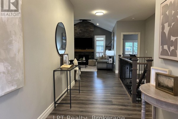 Hallway with grey walls, dark wood flooring, and a console table with a mirror. - 80 Ambrosia Terrace, Quinte West