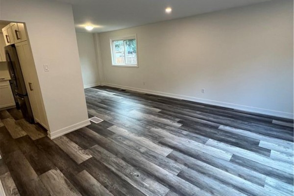 Open concept living and dining area with wood-look flooring and recessed lighting. - 80 Delawana Drive, Hamilton