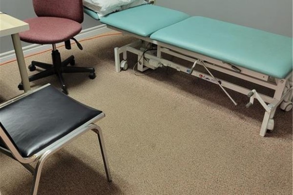 Another adjustable examination table with teal upholstery and beige carpeted flooring. - 80 Hamilton Street N Unit# 5, Waterdown