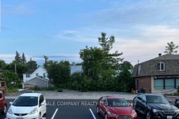 Parking lot with parked cars and trees under a partly cloudy sky. - 80 High Street, Mississippi Mills