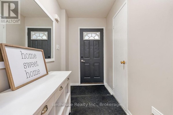 Interior entryway with a white console table, large mirror, and black front door. - 80 Lorne Street, Brock