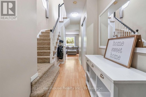 Hallway interior view showing a staircase, entryway console table, and mirror. - 80 Lorne Street, Brock