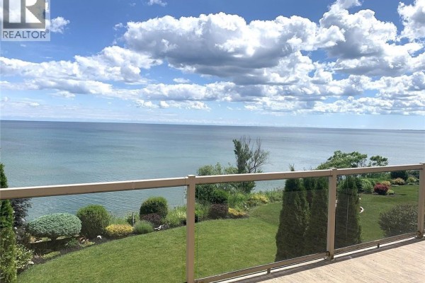 Backyard view featuring green lawn, neighboring houses, and outdoor seating area - 80 New Lakeshore Road Unit# 16, Port Dover