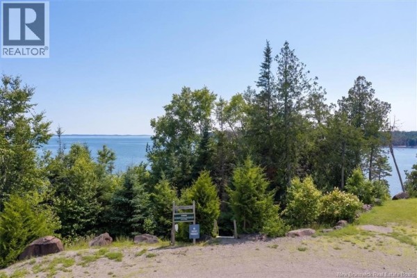 Wooded area with signage near the waterfront on a clear day. - 80 Osprey Drive, Chamcook