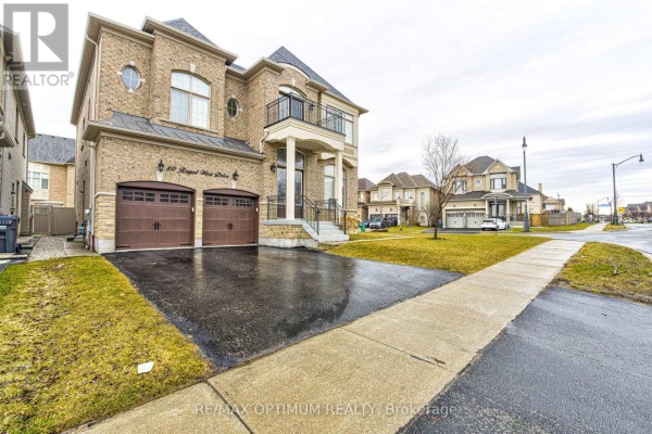 View of the front of a brick house with a double garage and a concrete driveway. - 80 Royal West Drive, Brampton