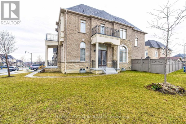 Side view of the house showing a large lawn and a covered balcony. - 80 Royal West Drive, Brampton