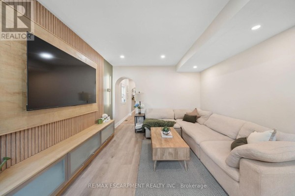 Living room with sectional sofa, wall-mounted TV, and media console - 80 Sarah Street Brant