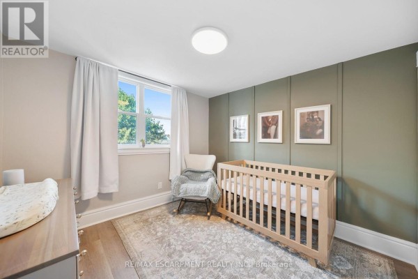 Nursery with crib, rocking chair, and accent wall - 80 Sarah Street Brant