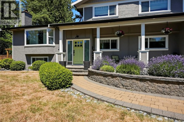 Close-up of the lime green front door with a stone pathway and lavender plants. - 800 Alvarado Terr, Saanich
