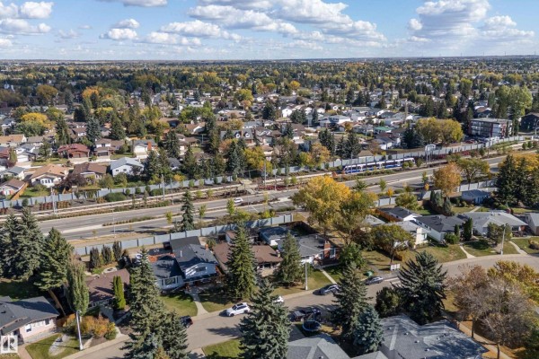 Aerial view of a suburban neighborhood with numerous houses, trees, and a train line. - 800 Lee Ridge Rd Nw, Edmonton