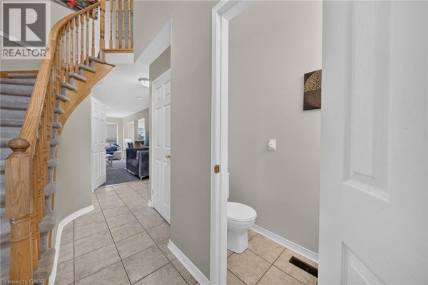 View of a half bathroom with a toilet and light gray walls off the hallway. - 800 Paramount Drive Unit# 77, Stoney Creek