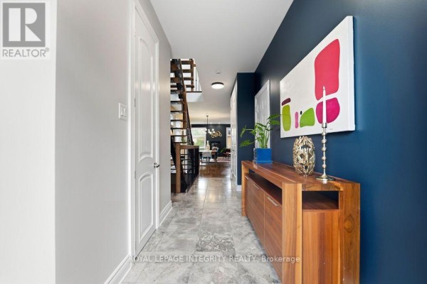 A long, bright foyer with light grey walls, blue accent wall, and tile flooring. - 800 Petra Private, Ottawa