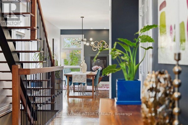 View down a hallway towards a dining room with a table, chairs, and fireplace. - 800 Petra Private, Ottawa