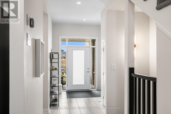 Interior entryway with white walls, a glass front door, and dark wood accents. - 800 Solarium Avenue, Ottawa