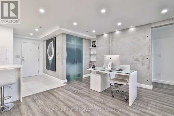 Home office space with glass partition, desk setup, and wood flooring - 801 - 10 Torresdale Avenue, Toronto