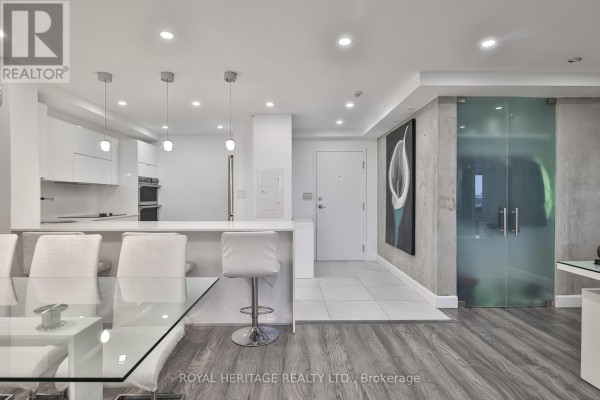 Dining area adjacent to kitchen, featuring a glass table and contemporary design - 801 - 10 Torresdale Avenue, Toronto