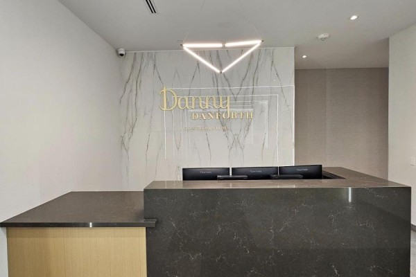 Close-up of reception desk featuring marble accents and modern lighting - 801 - 2369 Danforth Avenue, Toronto