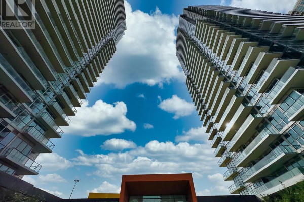 View looking up at two apartment towers against a blue sky. - 801 - 95 Mcmahon Drive, Toronto