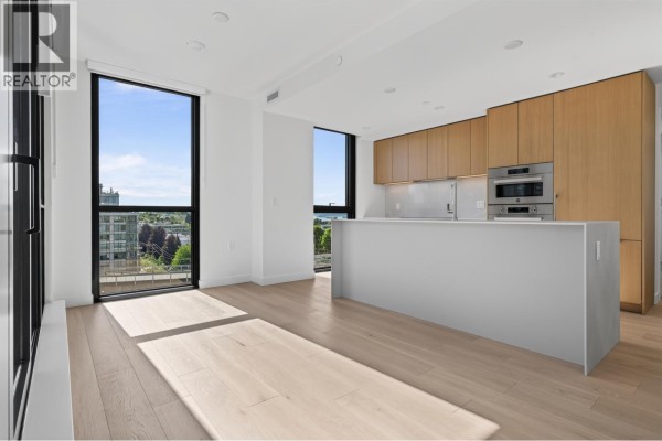 Bright living area with light wood floors, large windows, and a modern kitchen island and cabinets. - 801 1530 W 6th Avenue, Vancouver