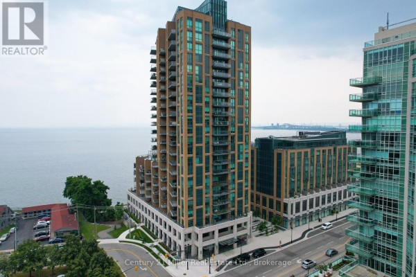 Aerial view of a tall condominium building on a cloudy day with a lake in the background. - 802 - 2060 Lakeshore Road, Burlington