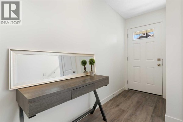 Entryway inside a townhouse with a console table, mirror, and front door. - 803, 24 Rivercrest Drive, Cochrane