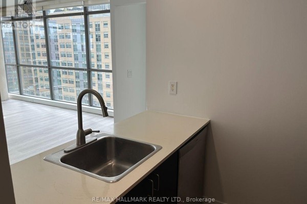 Kitchen counter with sink and faucet overlooking the living room and city view. - 803 - 281 Mutual Street, Toronto