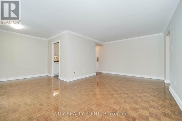 Living room with hardwood floors, crown molding, and an entrance to the kitchen. - 803 - 55 Isabella Street, Toronto