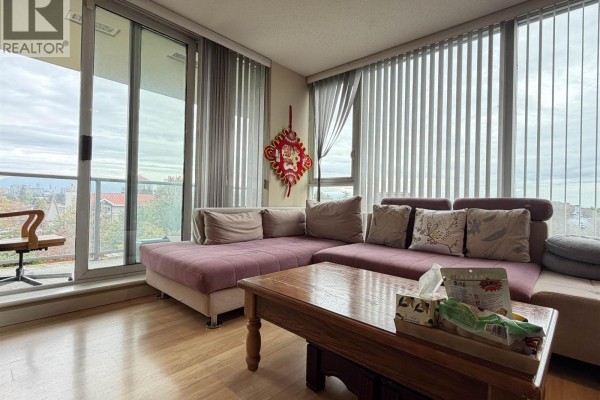 Living room with a large window, purple sectional sofa, and balcony access with a view. - 803 5068 Kwantlen Street, Richmond