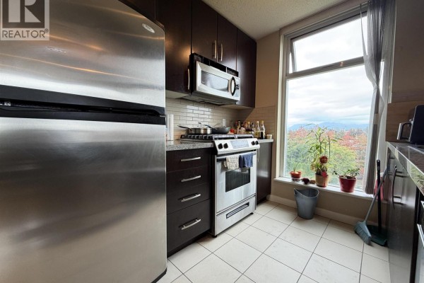 Kitchen with stainless steel refrigerator, oven, dark cabinets, and a large window with a view. - 803 5068 Kwantlen Street, Richmond