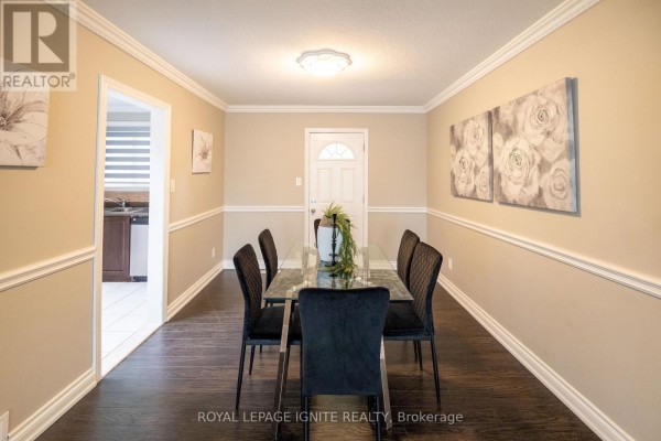 Interior view of a living room and entryway with wood paneling and a staircase. - 803 Fairview Avenue, Pickering