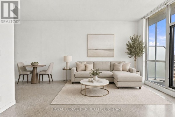 Living room furnished with a sectional sofa, coffee table, and dining set. - 804 - 510 King Street E, Toronto