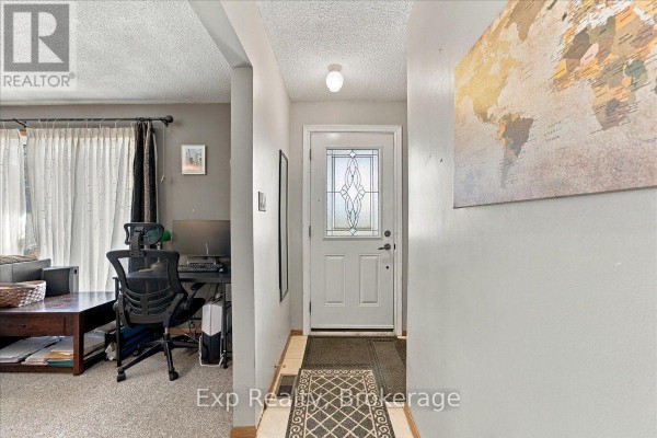 Interior hallway looking towards the front door, with a desk and world map on wall. - 804 Sherbrooke Street, Peterborough