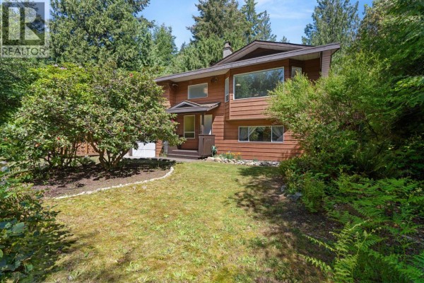 Exterior view of a brown two-story house surrounded by green trees and foliage. - 8044 Dogwood Drive, Halfmoon Bay