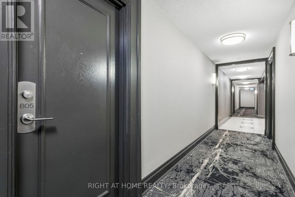 Dark grey apartment door with number 805 and a long hallway with patterned carpet. - 805 - 1103 Leslie Street, Toronto