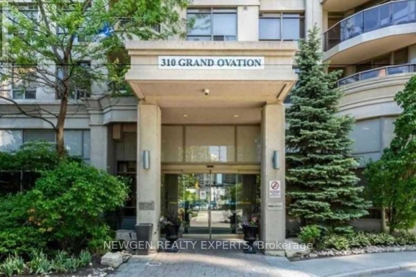 Entrance to the 310 Grand Ovation condominium building with glass doors and landscaping. - 805 - 310 Burnhamthorpe Road W, Mississauga