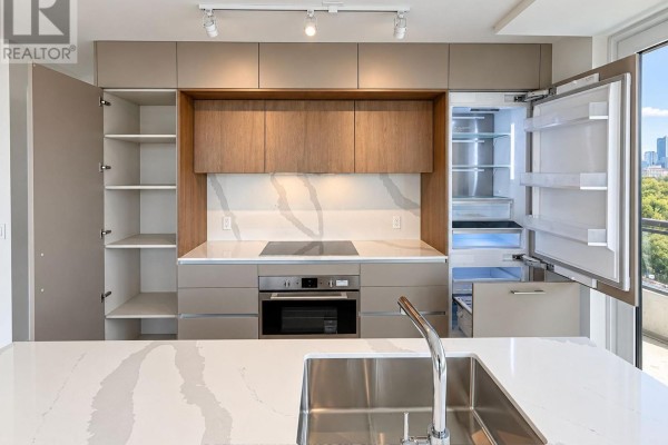 Kitchen cabinetry, stainless steel sink, microwave, oven, and open refrigerator with shelving. - 805 - 322 Dupont Street, Toronto