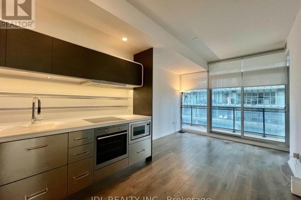 Open concept living area with a galley kitchen and a wall of windows overlooking the city. - 805 - 45 Charles Street, Toronto